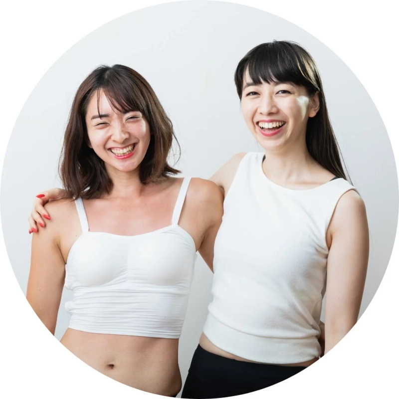 笑顔で肩を組む二人の女性